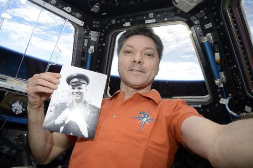 Russian cosmonaut Oleg Kononenko holds a photograph of the first person to fly into space - Yuri Gagarin