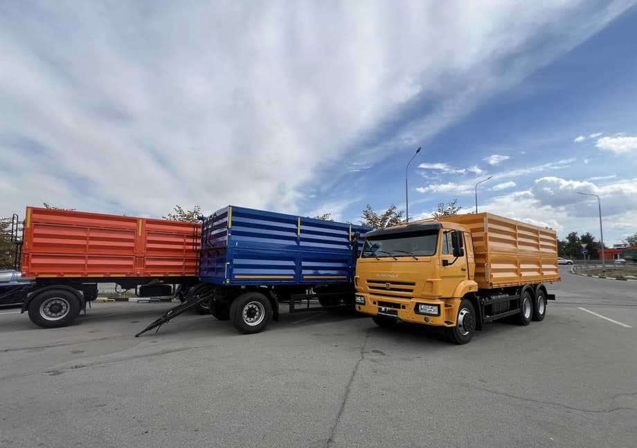 КАМАЗ на фоне прицепов для зерновых культур