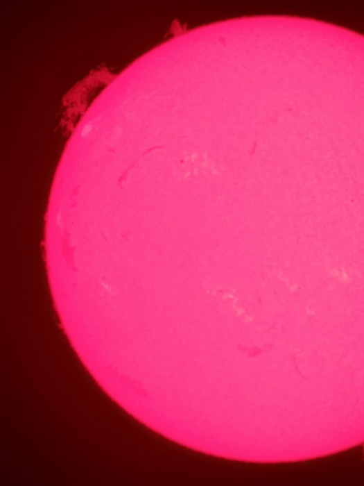 Солнечный протуберанец изображен в верхней левой части изображения